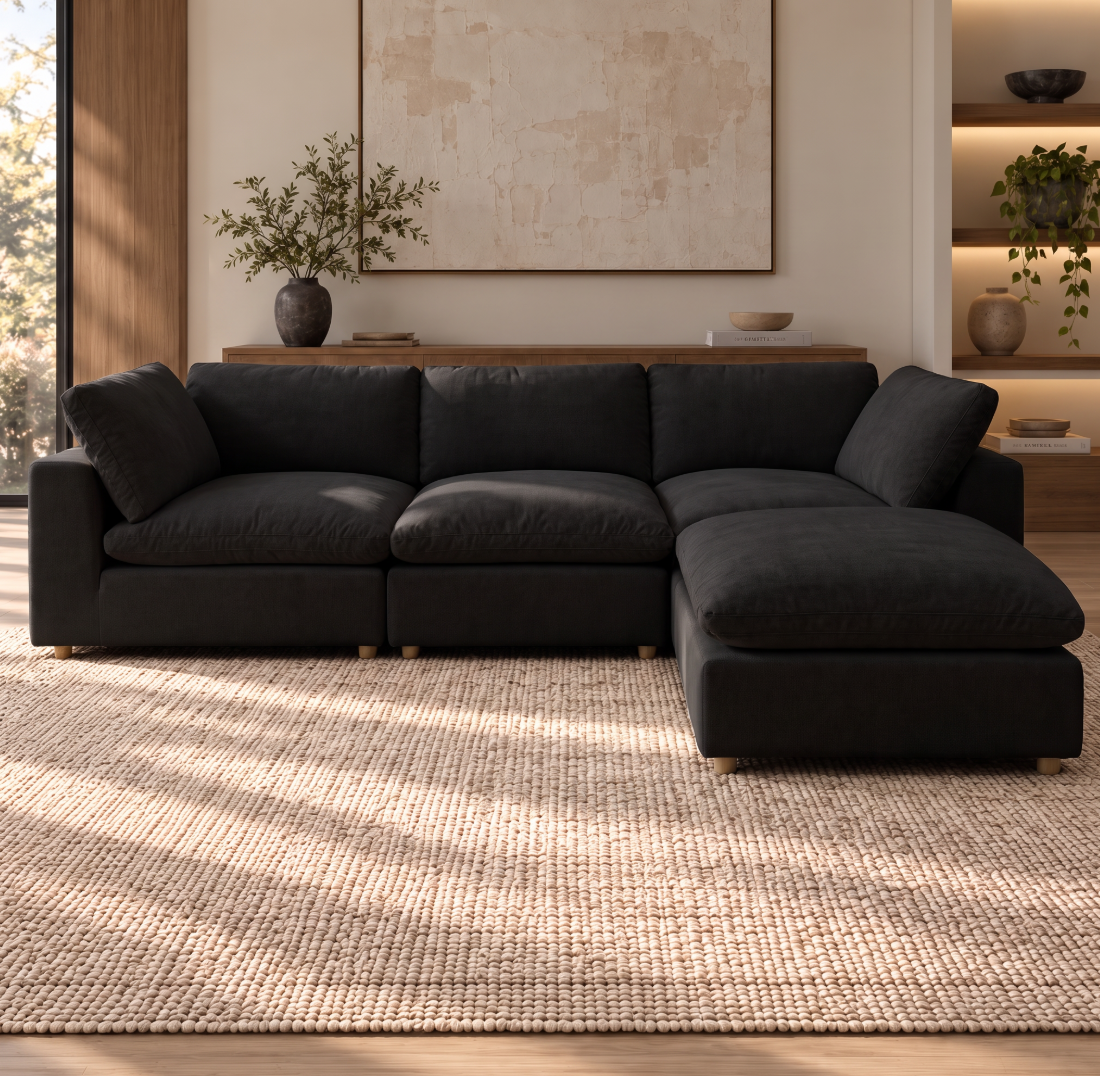 Norwick Black Down-Filled Cloud Couch — Black cloud couch with matching ottoman arranged as a chaise, shown in a room.
